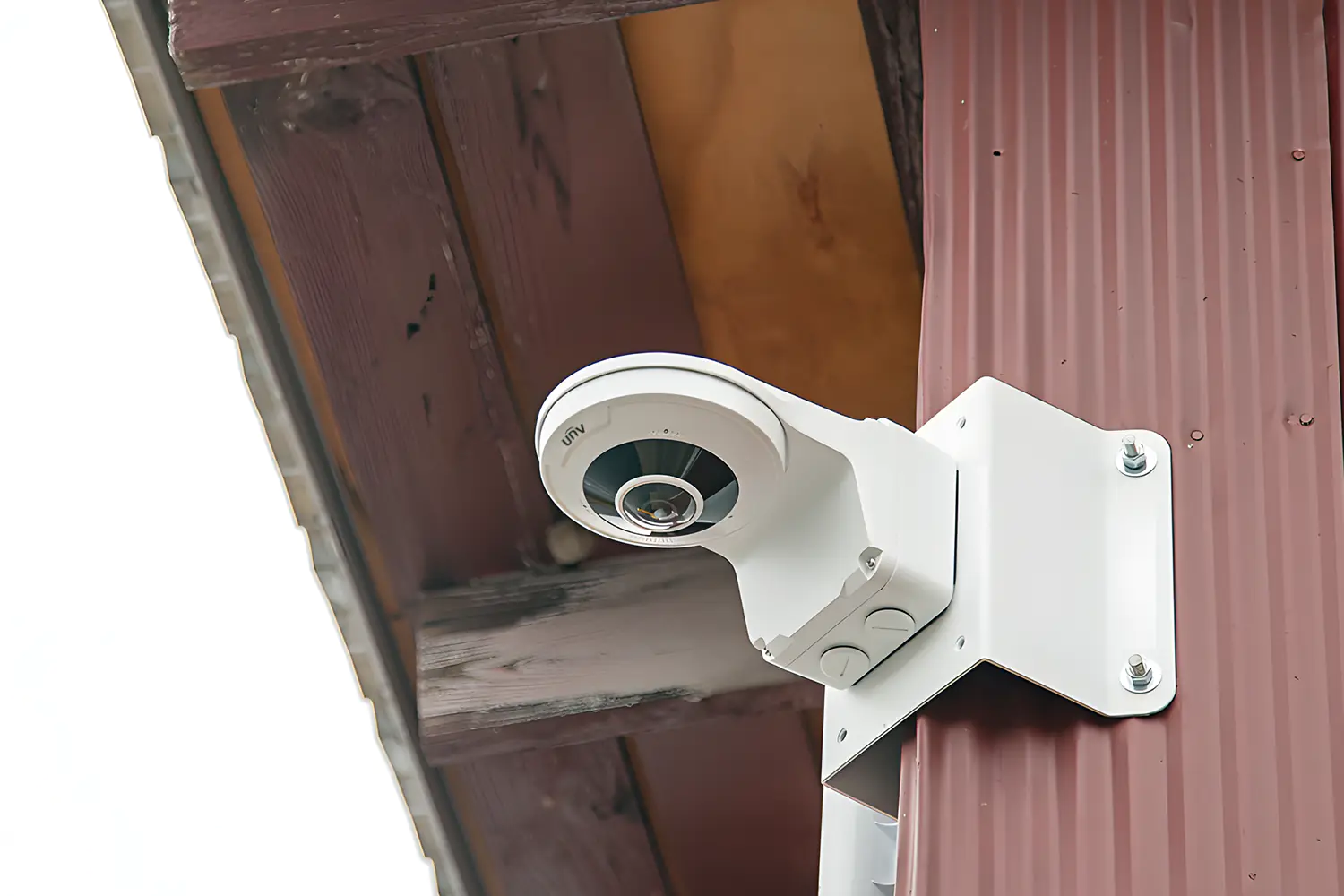 A fisheye security camera mounted on the corner of a warehouse building