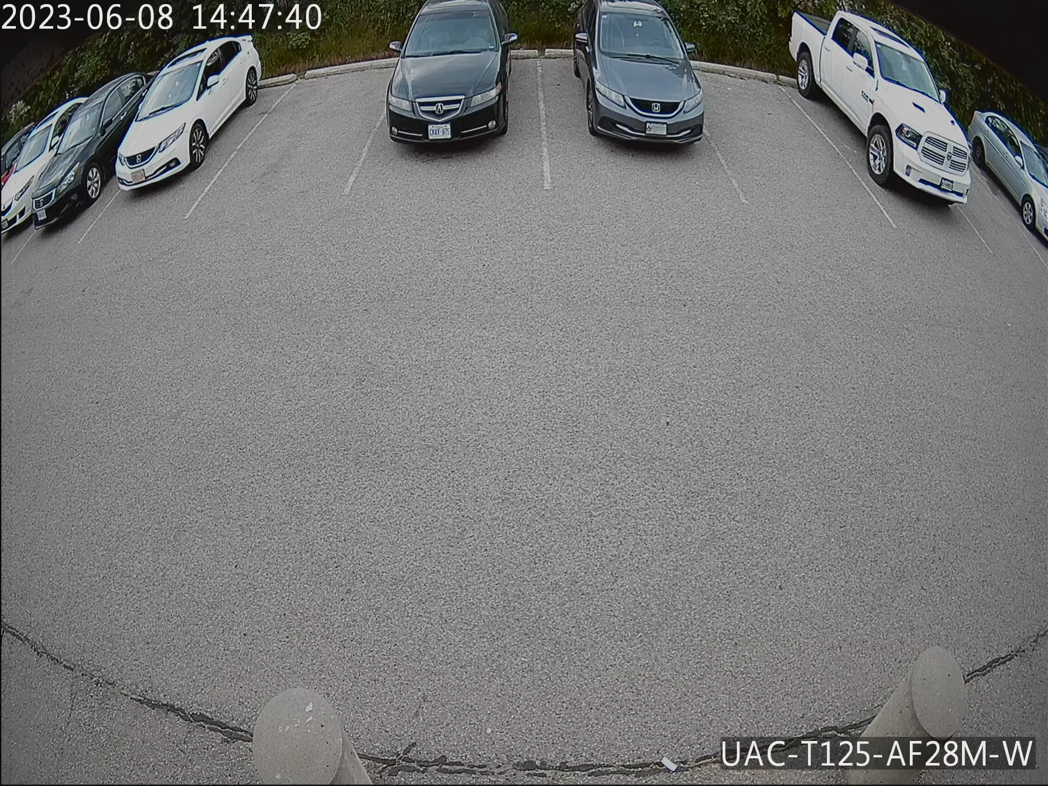 Security camera footage of a parking lot, slightly underexposed