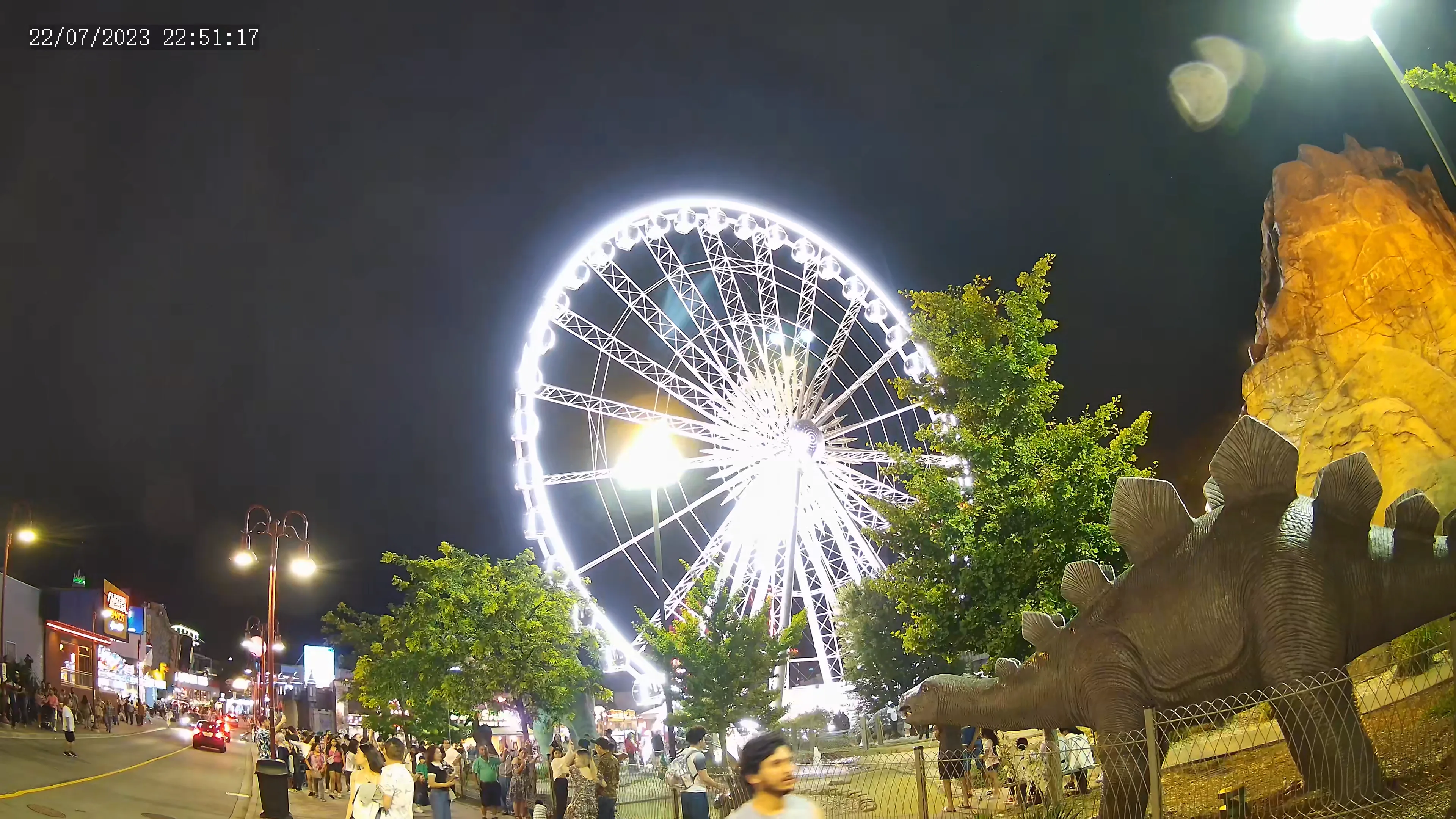 Niagara Falls skywheel at night with a dinosaur and volcano on the right