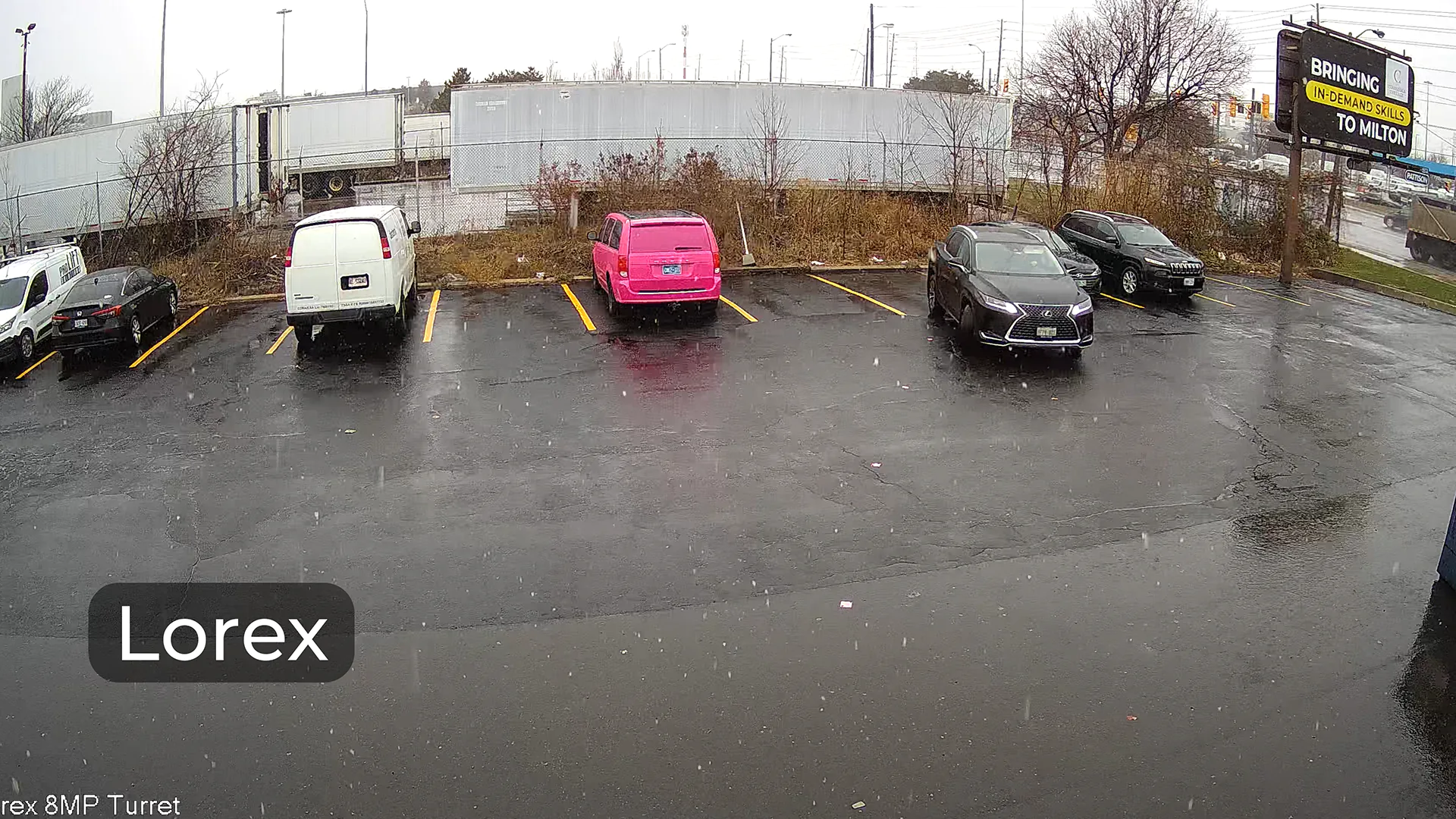 A snowy parking lot captured by a Lorex camera