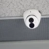 A Uniview 8MP turret camera mounted on a drop ceiling with a vent in the background