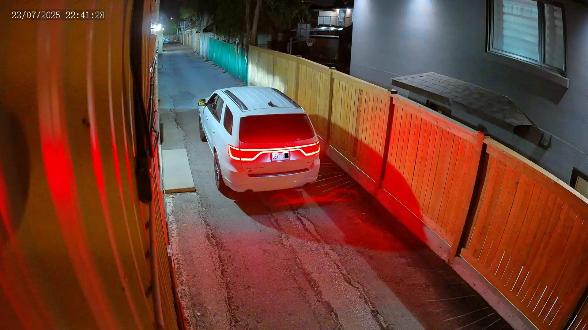 A snapshot taken from a Uniview security camera of a white van driving past at night. The license plate is clearly visible.