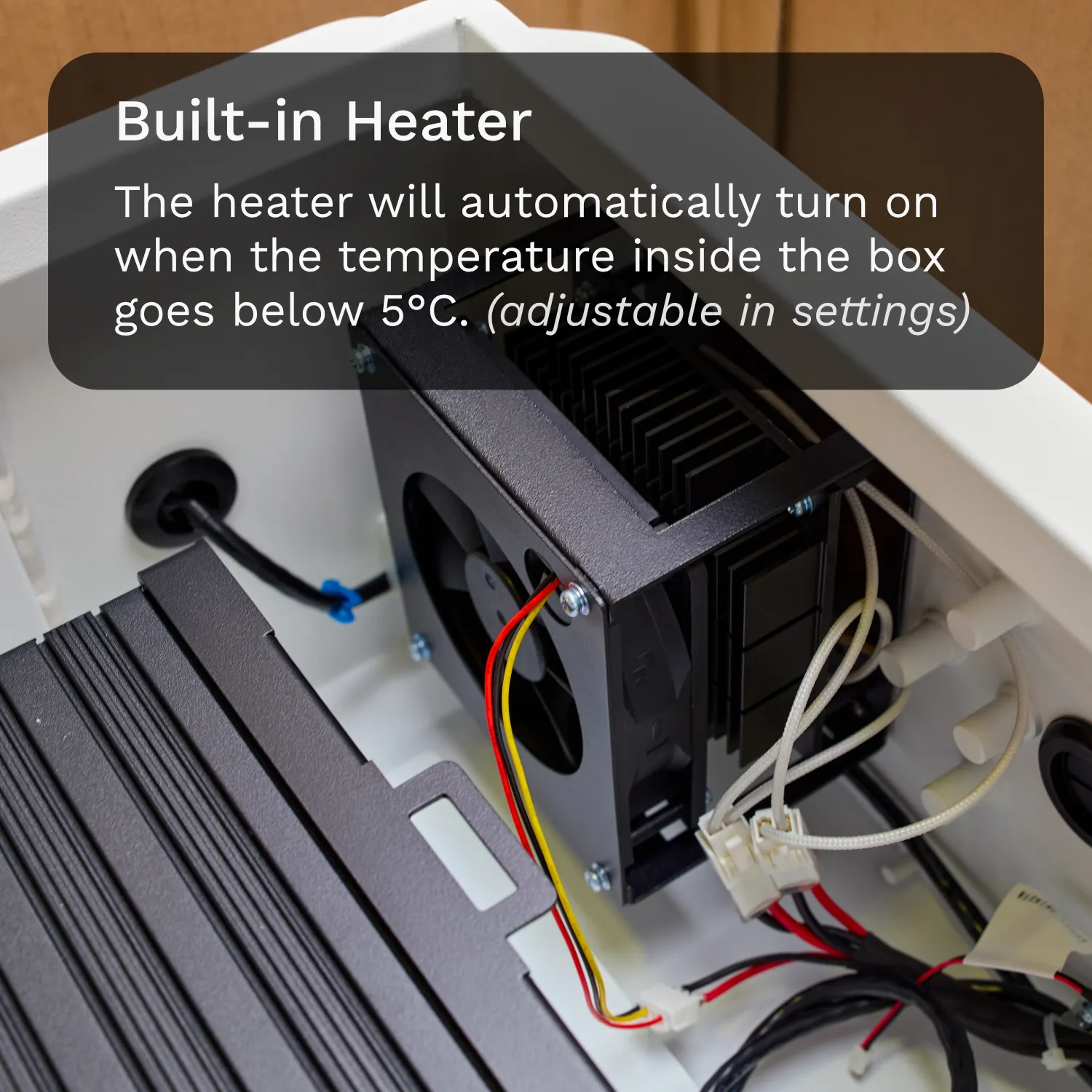 A thermostatic heater with a fan on top, with red, yellow, and black wires connected and leading away from it.