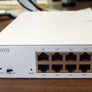 A white managed PoE switch from Lysora with a DIP switch for changing the LEDs between modes 1 and 2, plus a small hole for the reset button.