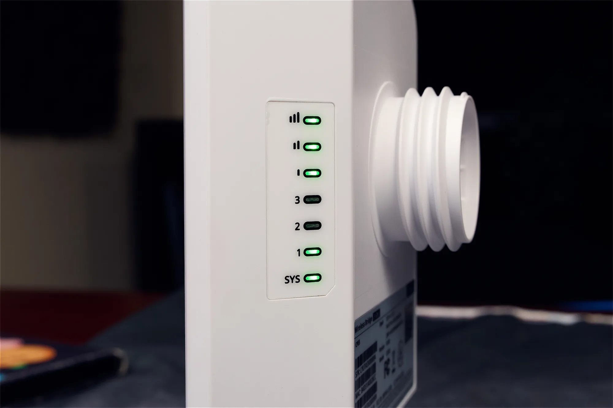 The side of a Lysora CPE5 wireless bridge with signal lights, three LAN port indicators, and a system indicator light.